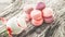 Raspberry and strawberry pink macaroons on pastel valentine decor and rose flowers soft background, shallow DOF. Gentle macaroons