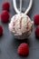 Raspberry-vanilla-icecream in icecream scoop, fresh raspberries on slate