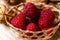 Raspberry wicker basket. Organic fruit. Home decor. Sweet fruit. Macro.