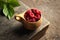 Raspberry in wooden kuksa mug. Cup of delicious raspberries stands on the wooden table