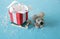 A rat pulls a sled with a red gift box with a white ribbon on a blue background. Christmas background. Christmas and New Year