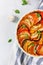 Ratatouille in baking dish on white background. Traditional French Provencal vegetable dish. Dieting, vegan food. Ratatouille