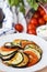 Ratatouille, vegetables cut on slices, eggplant, zucchini, tomatoes on plate