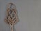 rattan carpet beater isolated on a gray wall background with little shadows