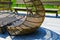 Rattan table and chaise longues near modern swimming pool, closeup