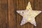 Rattans shining white Christmas star on weathered plank wood background, copy space for text, template for greeting card