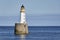 Rattray Head Lighthouse just off Rattray Point in Aberdeenshire in a calm Summer Sea.