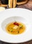 Ravioli consomme on a white porcelain plate. Healthy eating concept