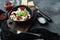 Ravioli pasta with mushroom cream sauce and cheese - Italian food style with basil parmesan and tomatoe in black bowl   on gray