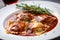 Ravioli stuffed with tender braised beef, served with rich red wine sauce and garnished with rosemary sprigs