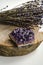 Raw amethyst rock with bunch of aromatic lavender flowers on natural wood rustic esoteric