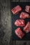 Raw angus beef slices on the black stone on the wooden table vertical