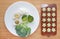 Raw of baby food broccoli, egg and rice in white plate and mashed baby food in container for freezing on wooden board