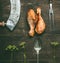 Raw barbecue marinated chicken drumstick with fresh herbs and kitchen utensils on rustic wooden background, top view. Grill