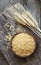 Raw barley noodle in bowl on wooden background with wheats