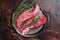 Raw Bavette or Sirloin flap beef meat steak with thyme. Dark background. Top view