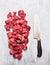 Raw beef goulash meat diced for stew with meat knife on light gray wooden background