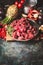 Raw Beef goulash of young bulls with vegetables and cooking ingredients on dark rustic background