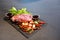 Raw Beef and herb ingredients, basil leaf, garlic, chilli, sauces are prepared on a black stone, slate plate for next cooking