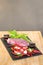 Raw Beef and herb ingredients, basil leaf, garlic, chilli, sauces are prepared on a black stone, slate plate for next cooking