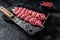 Raw beef Kofta kebab Skewers on a meat cleaver. Black background. Top view