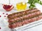 Raw beef lamb lula kebab on wooden skewer on a board, close up