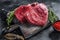 Raw beef liver offal on a cutting board. Black background. Top view