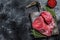 Raw beef liver offal on a cutting board. Black background. Top view. Copy space