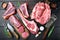 Raw beef meat steaks, tomahawk, t bone, club steak, rib eye and tenderloin cuts, on black wooden background, top view flat lay