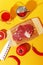 Raw beef meat on a wooden board and ingredients for cooking on a yellow background