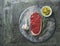 Raw beef steak background with garlic, pepper, rosemary and olive oil on round marble cutting board on dark kitchen table