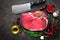 Raw beef steak on black background with cooking ingredients. Fresh beef meat