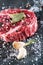 Raw beef steak fillet with ingredients like sea salt, pepper, bay leaves and onion on black board, image for restaurant,