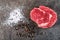 Raw beef steak fillet with ingredients like sea salt and pepper on black board, image for restaurant,