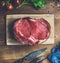 Raw beef steaks on wooden kitchen table background