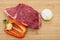 Raw beef on a wooden cutting board. Wooden background