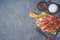 Raw blade steak of marbled beef on wooden board over dark background. Top view from above