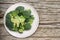 Raw broccoli head in white bowl