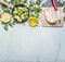 Raw broccoli in a pan with herbs, lemon, celery root on a cutting board with a knife border ,place text on wooden rustic backg