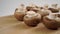 Raw brown mushrooms champignons on a wooden cutting board close-up.