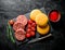 Raw burgers with cherry tomatoes, bread and rosemary