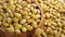 Raw Canary peruvian yellow beans falling into a rustic wooden bowl.