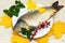 Raw carp on white plate with autumn leaf and flower