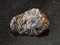 Raw Cassiterite Tin ore stone on black