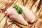 Raw chicken breasts and spices on wooden cutting board, close up