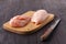 Raw chicken breasts and spices on wooden cutting board, close up view