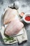 Raw chicken Breasts on a white chopping Board. Organic farm bird. Fresh fillet with skin. Gray background