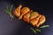 Raw chicken drumstick with spices and green rosemary on a black background . Raw chicken skewers on skewers.Convenience food,