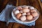 Raw chicken eggs on white plate with whisk on wooden background. Ready to start the cooking concept