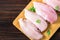 Raw chicken fillets on a cutting board against the background of a wooden table. Meat ingredients for cooking. Empty place for an